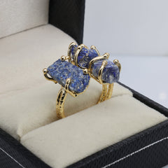 Artisan-made gold ring showcasing raw amethyst, green gemstone, and red crystal.
