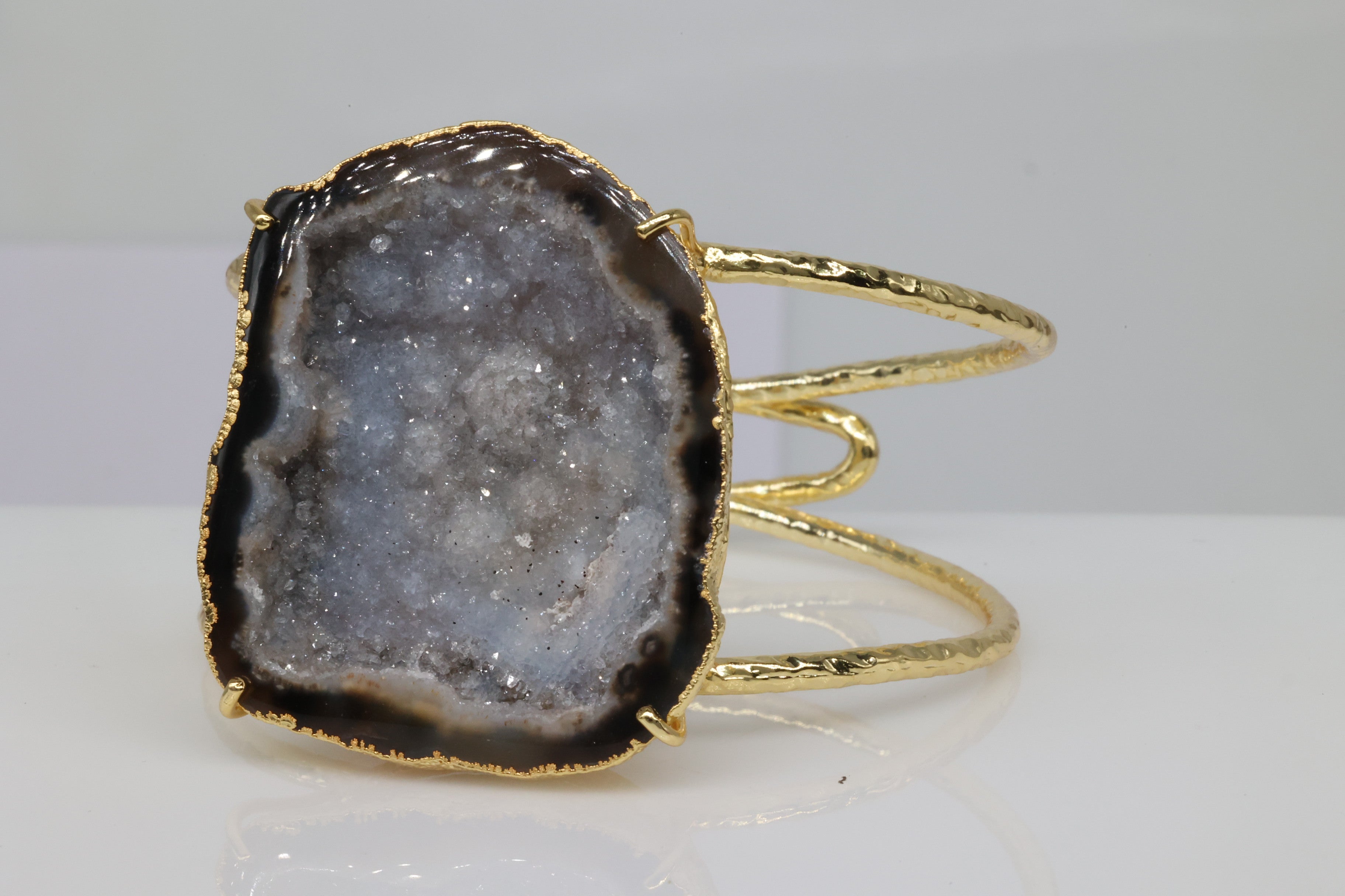 Gold-plated cuff bracelet with natural grey geode slice.