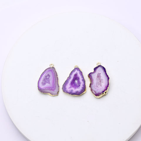 Vibrant purple agate geode charms with rough druzy interiors and connector loops