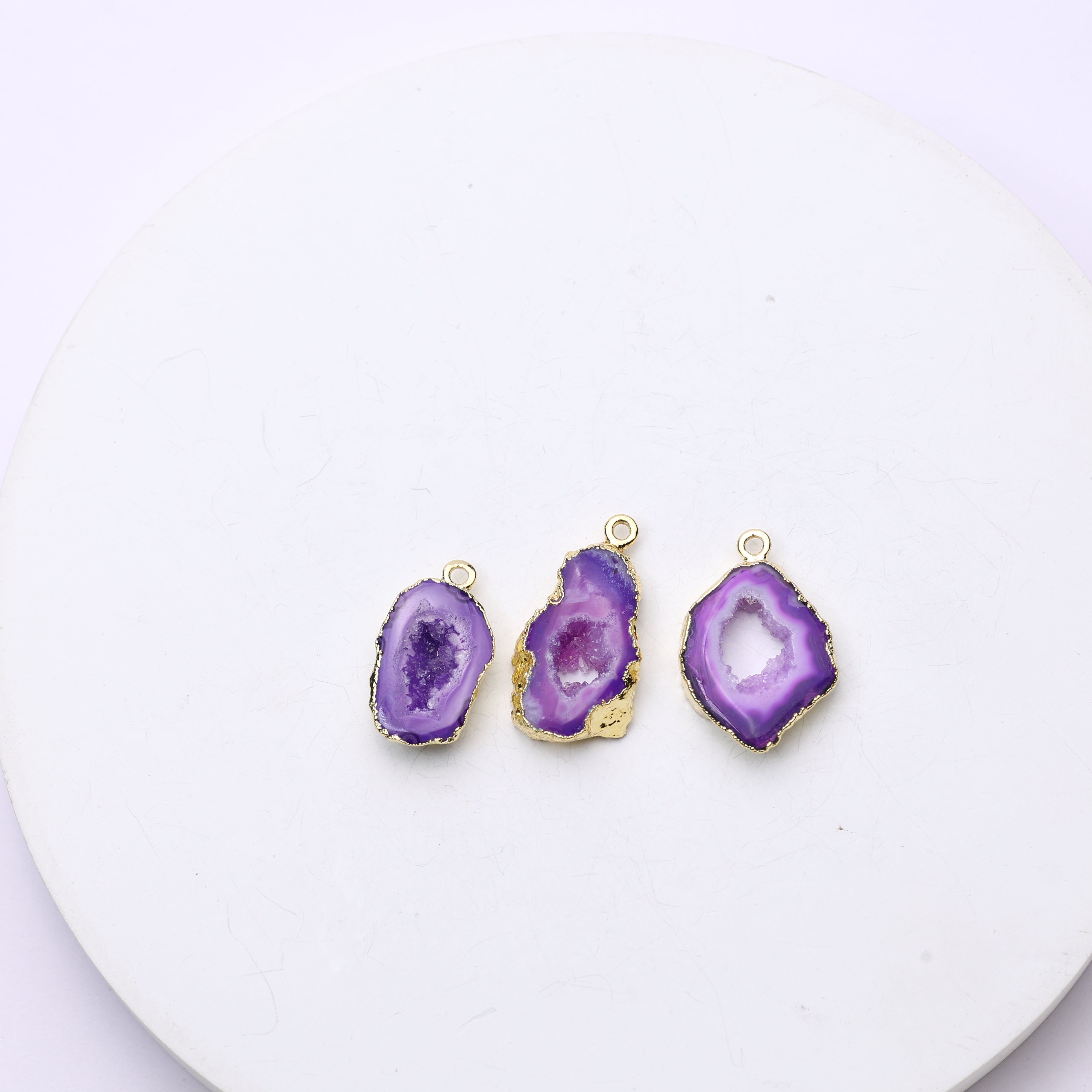 Thin geode slice charm bordered in gold with natural druzy crystals