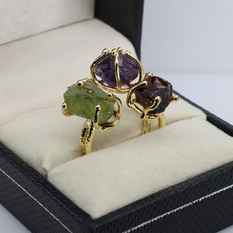 Triple gemstone adjustable ring featuring raw purple, green, and red stones.