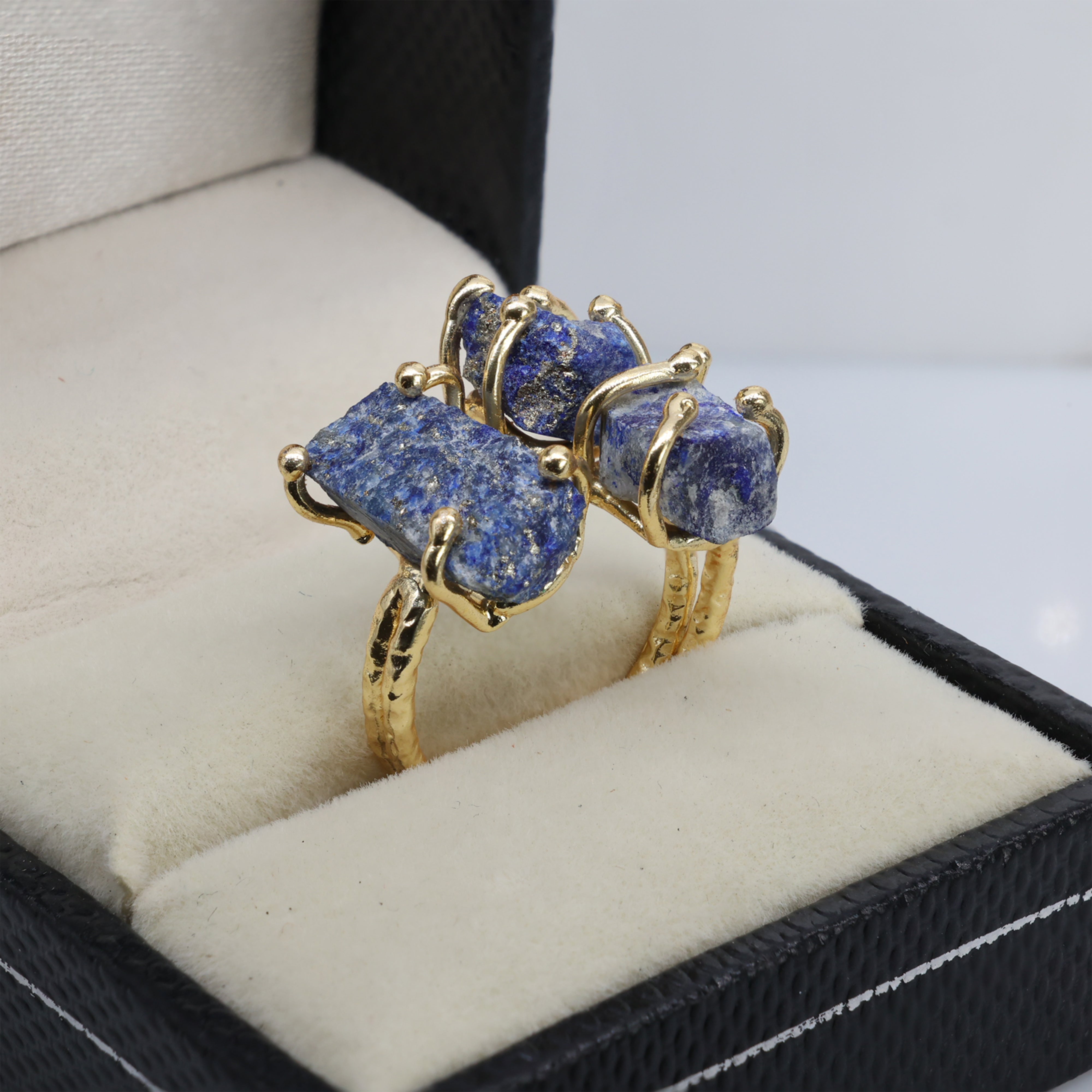 Artisan-made gold ring showcasing raw amethyst, green gemstone, and red crystal.