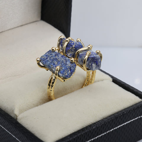 Artisan-made gold ring showcasing raw amethyst, green gemstone, and red crystal.